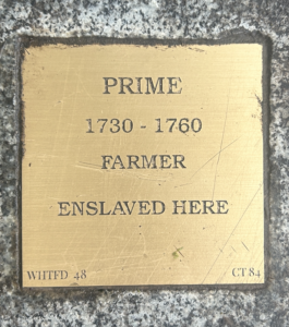 Historical plaque honoring Prime, an enslaved farmer from 1730-1760, highlighting his contribution and legacy.
