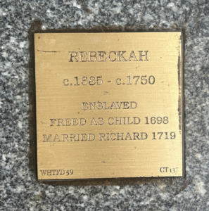 Plaque for Rebeckah: Born c.1685, freed in 1698, married Richard 1719, died c.1750. History and legacy remembered.