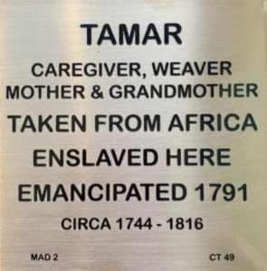 Plaque honoring Tamar, an African caregiver and weaver, emancipated in 1791, detailing life dates 1744-1816.