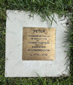 Bronze plaque on grass commemorating Peter, enslaved farmer in Longmeadow, circa 1735-1774, husband of Phillis.