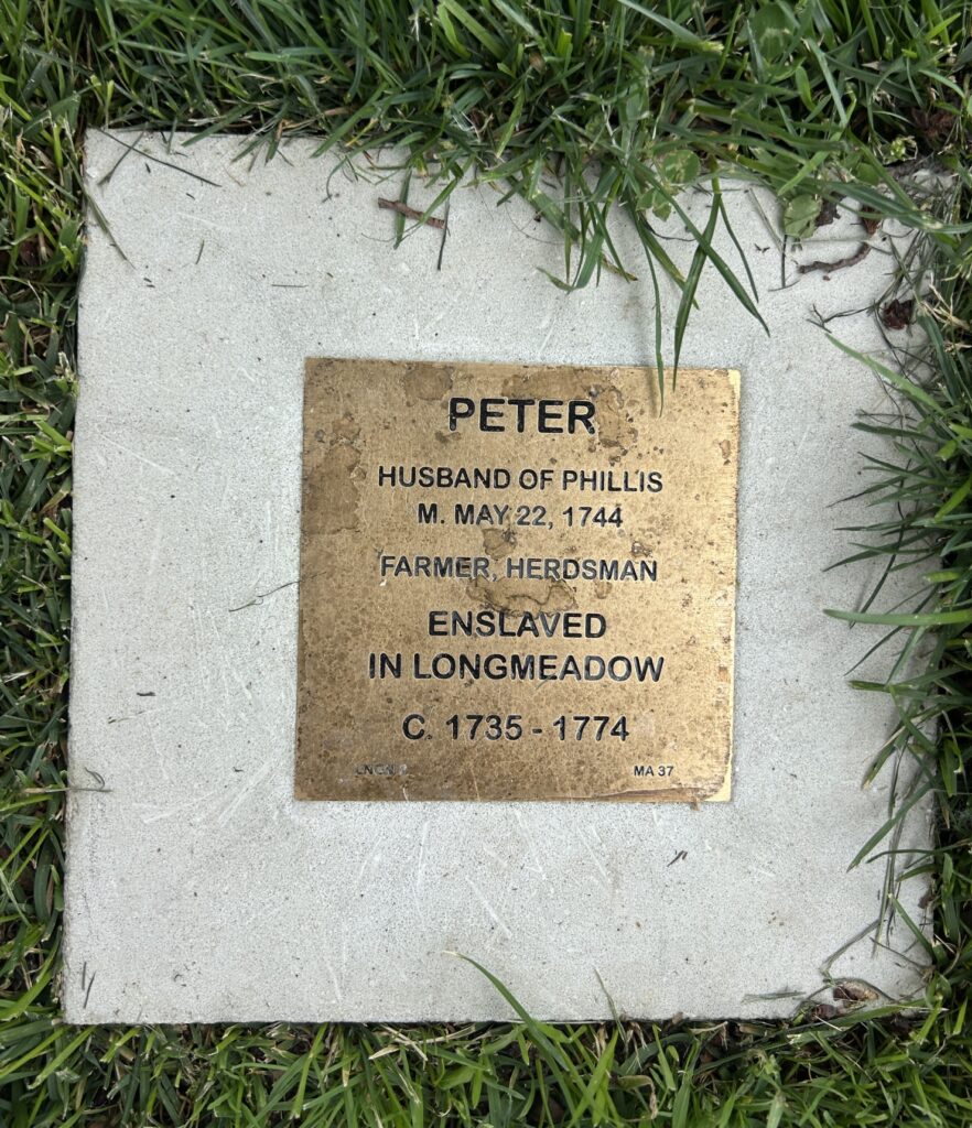 Bronze plaque on grass commemorating Peter, enslaved farmer in Longmeadow, circa 1735-1774, husband of Phillis.