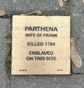 Memorial plaque for Parthena, enslaved and killed in 1704, highlighting historical injustice at site.