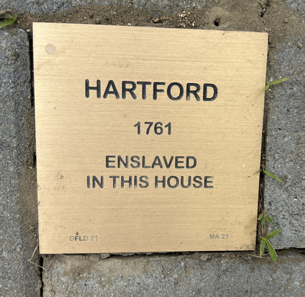 Plaque indicating historical enslavement in Hartford, 1761, embedded in a brick pathway.