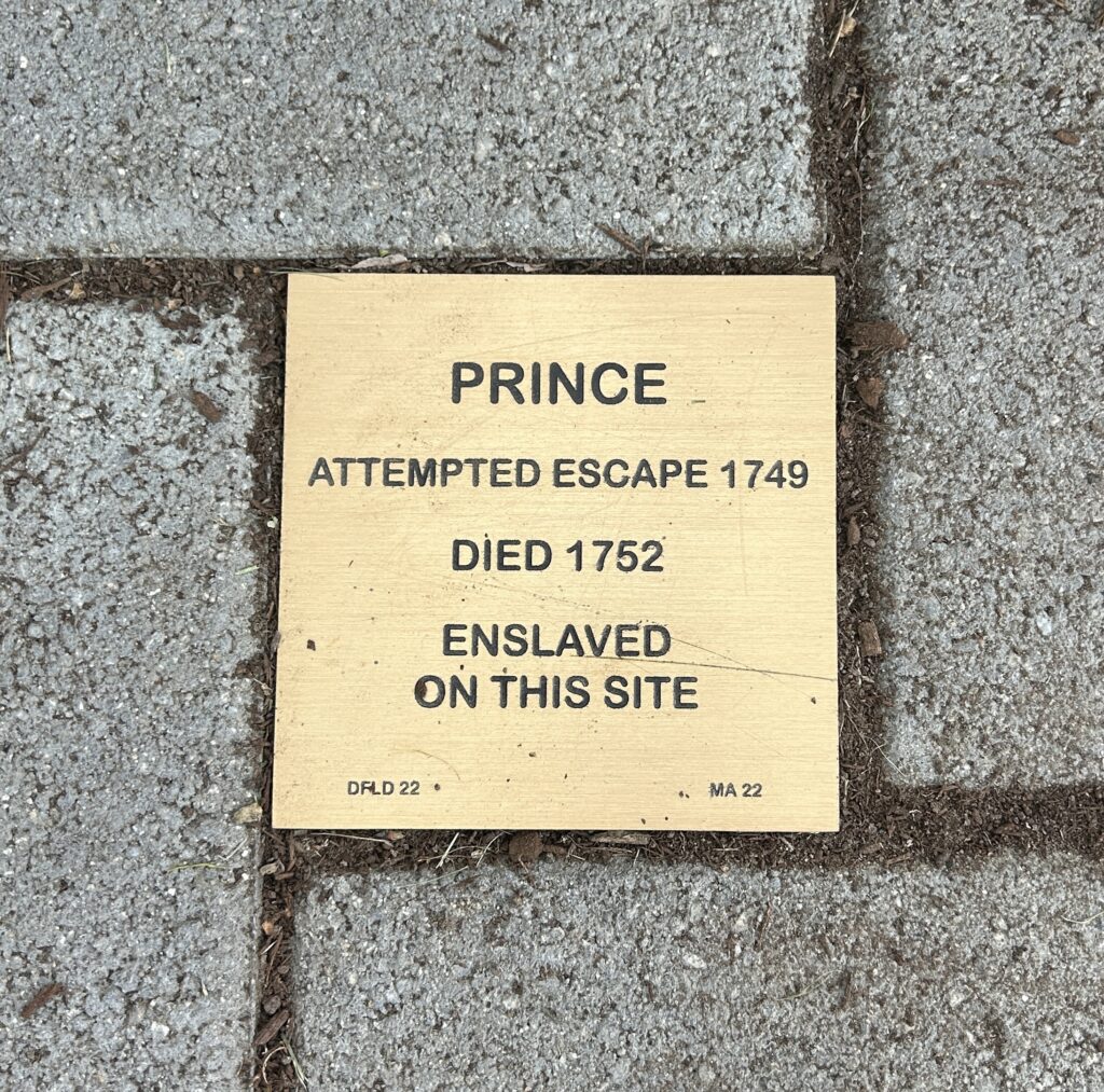 Memorial plaque for Prince, who attempted escape in 1749 and died 1752, enslaved at this site.