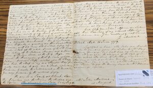 Historic handwritten letter from 1779 discussing land and family matters, placed on a wooden table.