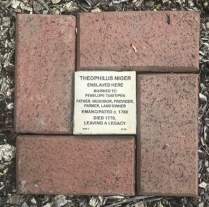 Memorial brick for Theophilus Niger, highlighting his life, emancipation, and legacy in a historical context.