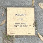 Commemorative plaque for Kedar, enslaved in 1729, with historical significance.
