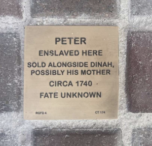 Plaque honoring Peter, an enslaved individual, and Dinah, sold in 1740. Fate unknown. Historical remembrance marker.