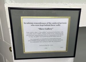 Plaque in solemn remembrance of enslaved persons in a historical Slave Gallery from 1808-1842, acknowledging past injustices.