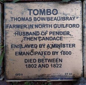 Commemorative plaque for Tombo, a North Guilford farmer and emancipated individual, detailing life events and family.