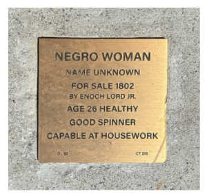 Plaque commemorating a historical slave sale, highlighting the sale of an unnamed woman in 1802 for housework skills.