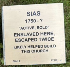 Plaque honoring Sias, enslaved and escaped twice, key in local church construction. Active, Bold.