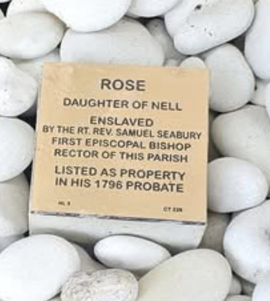 Commemorative plaque for Rose, enslaved by Episcopal Bishop Samuel Seabury, positioned among white stones.