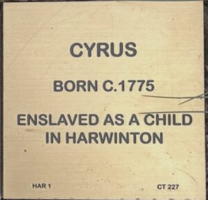 Plaque honoring Cyrus, born circa 1775, who was enslaved as a child in Harwinton, highlighting historical context.