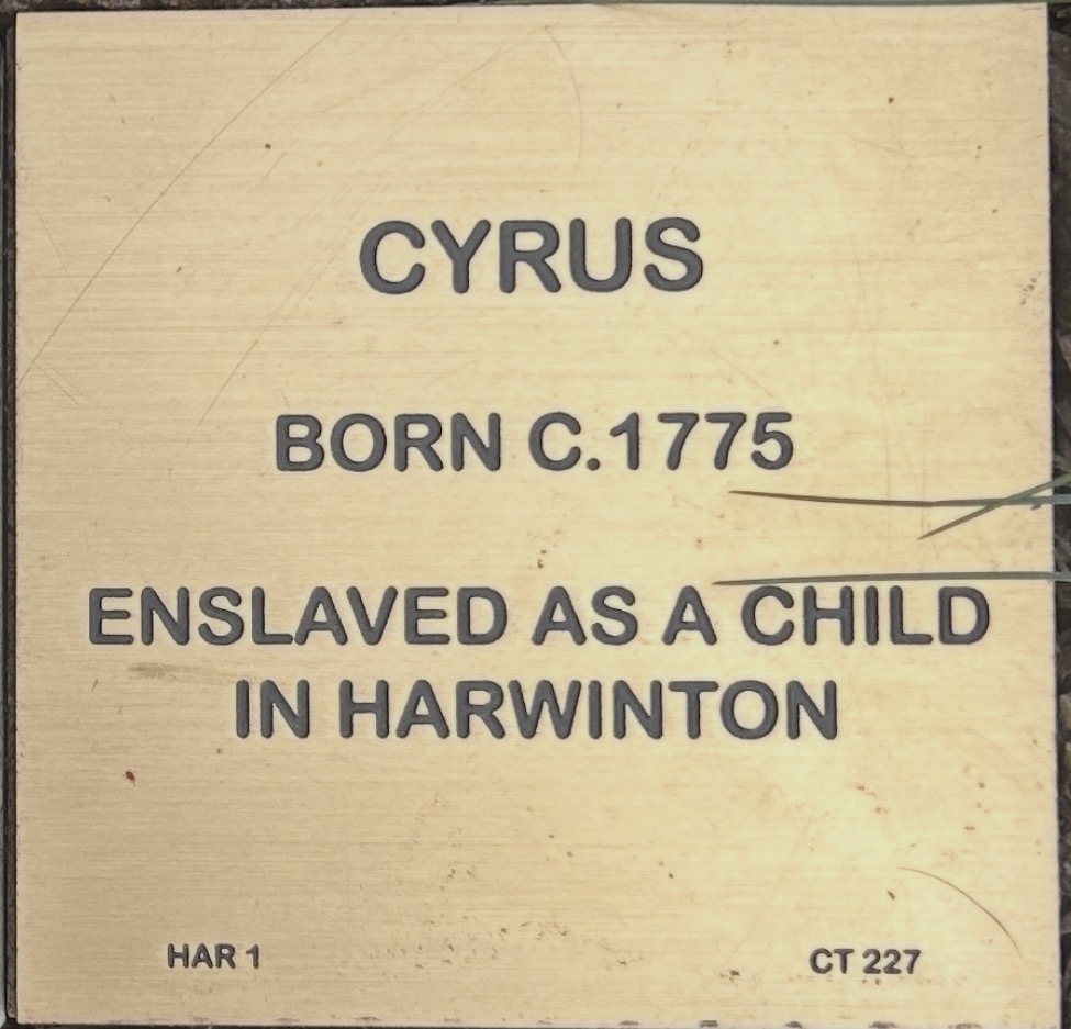 Plaque honoring Cyrus, born circa 1775, who was enslaved as a child in Harwinton, highlighting historical context.
